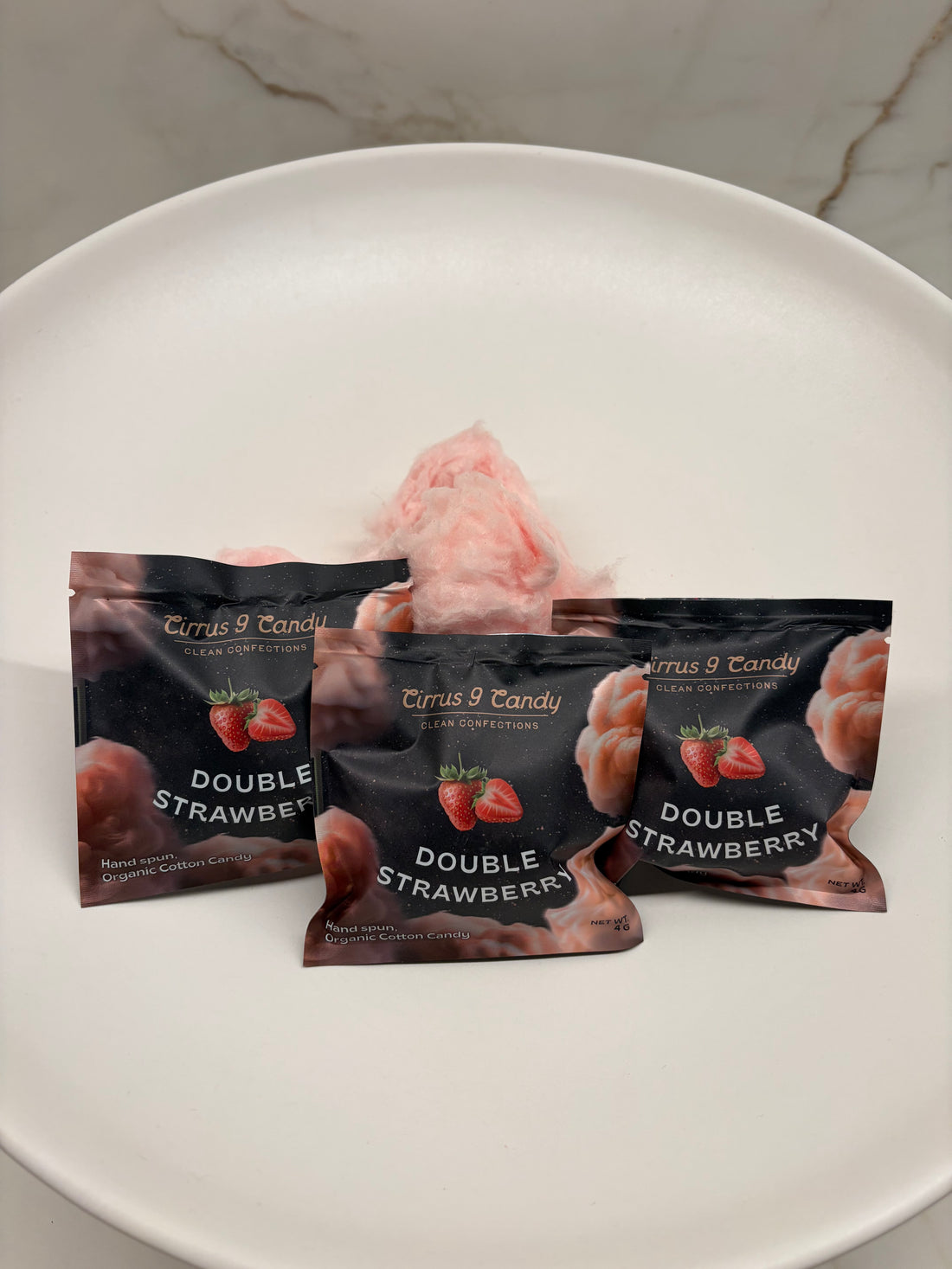 Hand holding a product package against a marble and wood surface